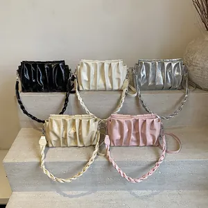 Fashionable pleated cloud crossbody bag for women in five colors on stone steps