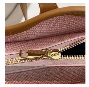 Close-up of golden metal zipper and pink fabric lining on a tote bag interior detail