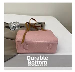 Detail view of the wear-resistant bottom with reinforced patches on pink tote bag
