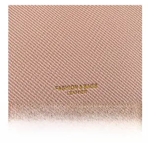 Detail of pink tote bag showing diagonal leather texture and golden embossed logo