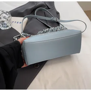 Detail of light blue PU leather handbag with silver chain strap and adjustable shoulder strap
