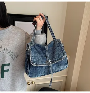 Detail of vintage washed denim tote bag showing metal buckle and retro texture