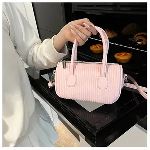 Pink cylinder handbag featuring vertical pleated texture and silver zip closure detail