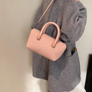 Sac fourre-tout rose texturé chic avec poignée et bandoulière sur manteau gris