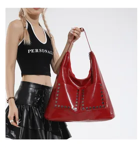 Macro shot of red glossy patent leather tote with hexagonal metal rivet decorations