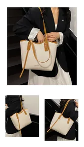 Detail of ivory tote bag with caramel leather straps and textured surface design