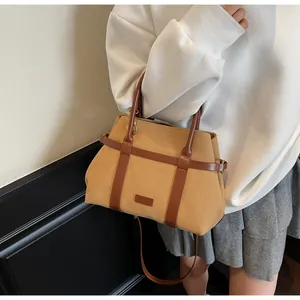 Borsa tote bicolore minimalista color cammello e marrone indossata come borsa a tracolla