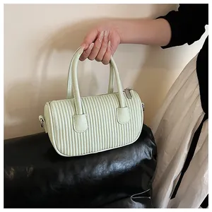 Detail of mint green cylindrical handbag with vertical pleats and lychee texture