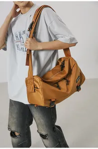 Dettaglio della grande borsa a tracolla kaki con fibbie regolabili e trama in nylon resistente