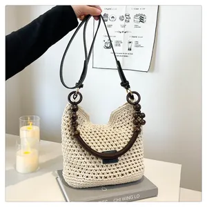 Detailopname van geweven shopper met gebreide textuur en decoratieve donkere houten kralen