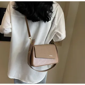 Gros plan du sac à bandoulière marron vintage avec rabat tressé et logo doré mode