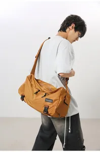 Dettaglio della grande borsa a tracolla marrone con tasche con zip ed etichetta MINGDAILD