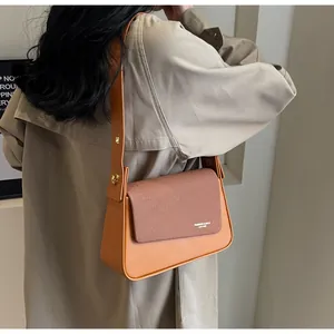 Détail du sac à bandoulière vintage en cuir orange-brun et sergé avec boucle dorée
