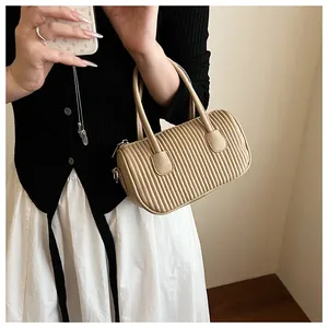 Close-up of vertical pleated texture on khaki PU leather boston bag with metallic zipper