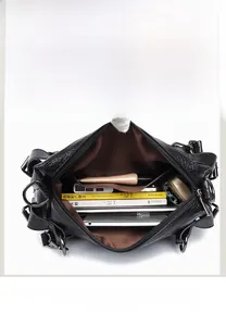 Internal view of a black pebbled leather tote showing spacious multi-compartment design