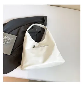 Macro detail of the smooth white faux leather hobo tote bag with a front zipper pocket