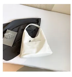 Close-up of white leather hobo bag back side with functional metal zipper pocket