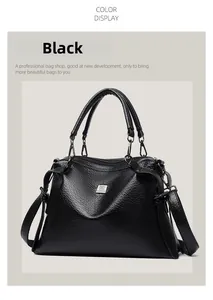 Close-up of black pebble leather handbag featuring metal logo plaque and dual handles