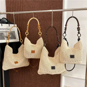 Handgeweven crème hobo draagtas met stijlvolle houten kralen handvaten en mesh textuur