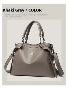 Detail view of khaki grey leather handbag with textured finish and wide shoulder strap