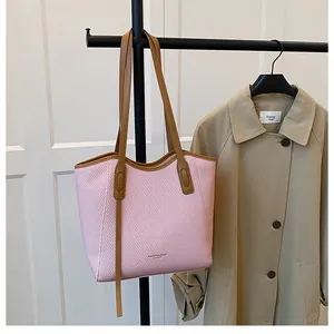 Detail of fashion tote bag with pink houndstooth pattern and brown leather trim