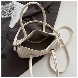 Close-up of cream pleated handbag interior with metal zipper and textile lining