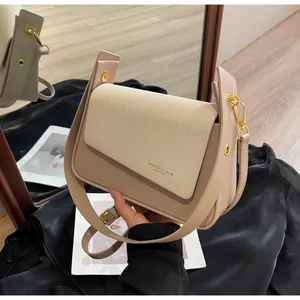 Détails d'un sac bandoulière beige avec rabat matelassé et ferrures en métal doré