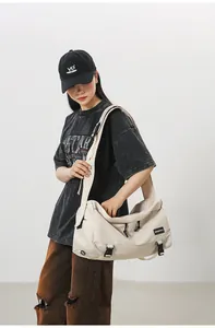 Dettaglio borsa a tracolla in nylon beige impermeabile con fibbia regolabile ed etichetta