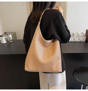 Gros plan sur le sac cabas tressé beige montrant la texture et la grande capacité