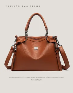 Detailed macro view of the brown lychee-patterned PU leather and gunmetal hardware logo