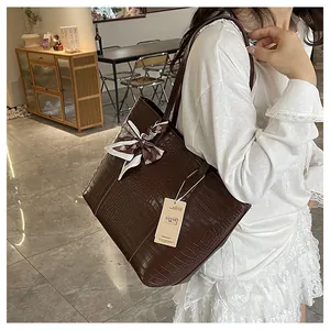 Détail du sac cabas vintage marron gaufré crocodile avec foulard chic en soie