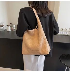 Détail de la texture en cuir tressé d'un grand sac hobo kaki pour femmes