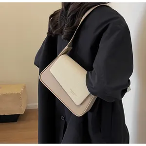Détail du sac à bandoulière en cuir et tissage beige avec logo doré et texture