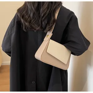 Sac bandoulière beige avec patchwork et bandoulière minimaliste porté par modèle