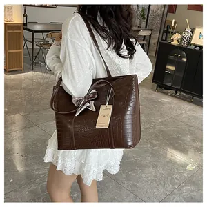 Détail du sac cabas marron foncé motif crocodile avec foulard en soie décoratif