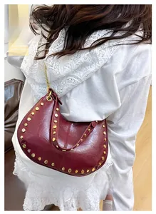Sac demi-lune bordeaux chic avec clous dorés et bandoulière chaîne sur mannequin