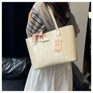 Détail du sac cabas crème avec texture crocodile et foulard en soie décoratif