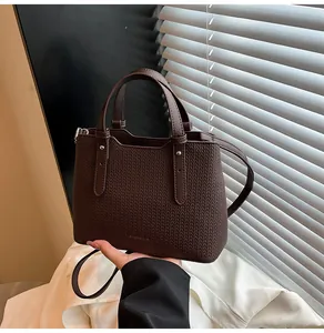 Dettaglio di borsa tote marrone scuro in similpelle testurizzata con doppi manici