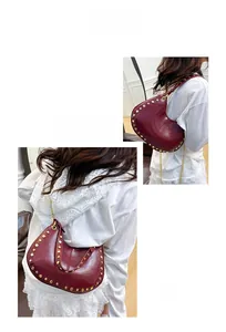 Vue détaillée du sac croissant bordeaux orné de rivets dorés élégants sur les bords