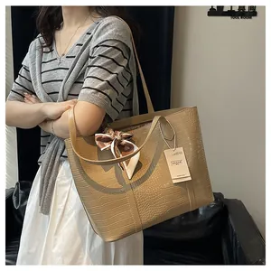 Détail du sac cabas beige à motif crocodile avec un foulard élégant sur la poignée