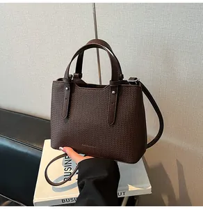 Dettaglio della borsa tote marrone scuro con trama intrecciata e logo in rilievo