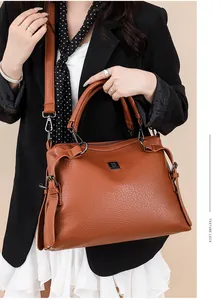 Close-up of caramel leather tote bag with lychee texture and metallic logo detail