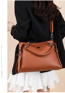 Side view of woman carrying a brown textured leather shoulder bag in a business outfit