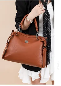 Brown textured leather tote bag with silver metal logo shown in a business casual style