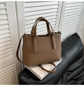 Dettaglio della borsa tote marrone con trama intrecciata e finiture in argento lucido