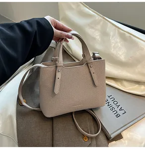 Dettaglio borsa tote beige testurizzata con rivetti argento e stile elegante a mano