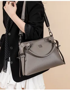 Detail of grey lychee leather texture and gunmetal hardware on a large tote bag