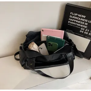 Vue intérieure du grand sac cabas noir montrant des compartiments spacieux pour accessoires