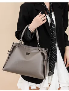 Detailed view of grey lychee leather handbag paired with professional office attire