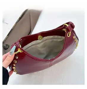 Détail du sac à main punk bordeaux montrant le fermoir magnétique et la poche zippée